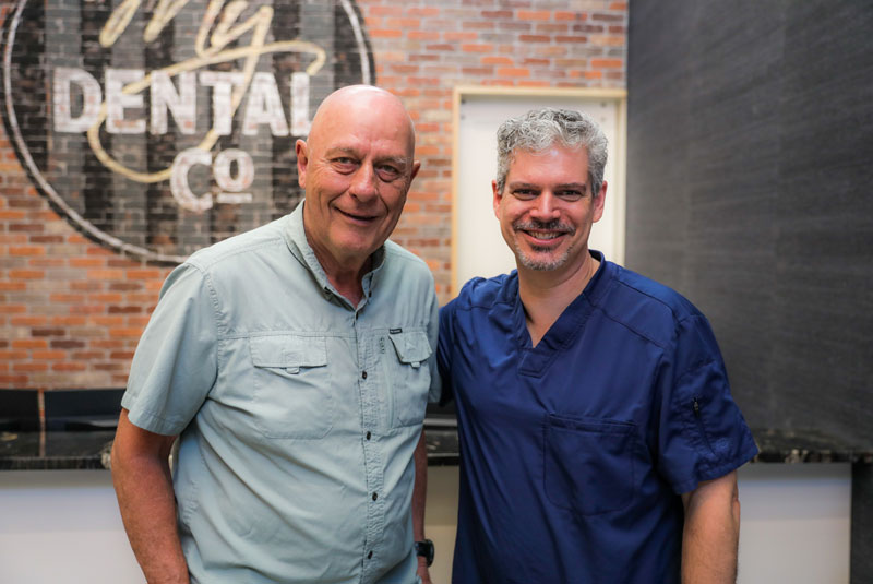jim_olson_dental_crown_bridge_2 patient standing by Dr. Olson